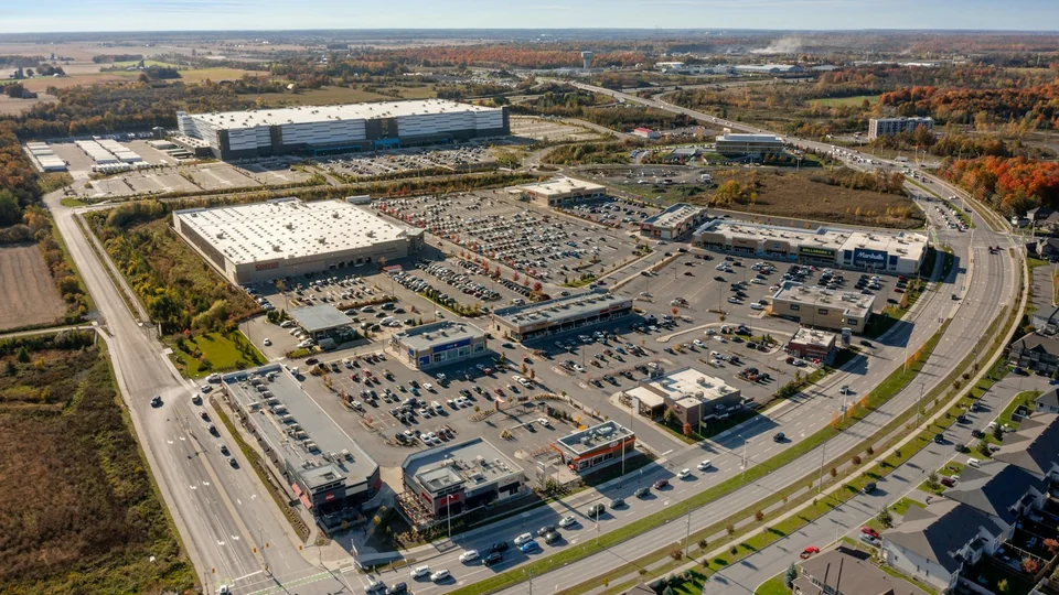 Aerial photograph of a retail center with multiple buildings, parking areas and connecting routes